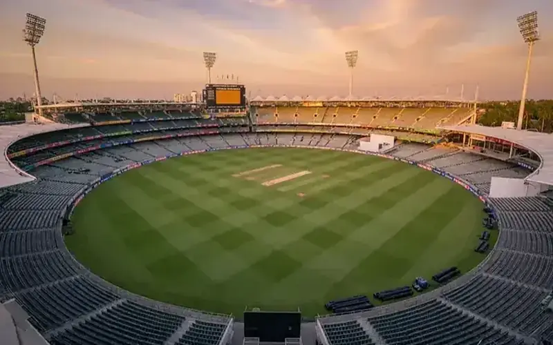 Cricket stadium scoreboard glowing at twilight